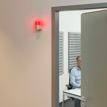 Cargar imagen en el visor de la galería, Yellowtec Do Not Disturb Light red ON next to semi closed office door with people having a call
